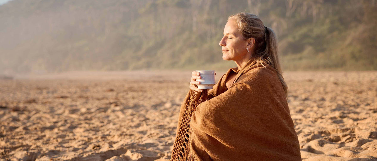Woman sipping cacao powder on beach